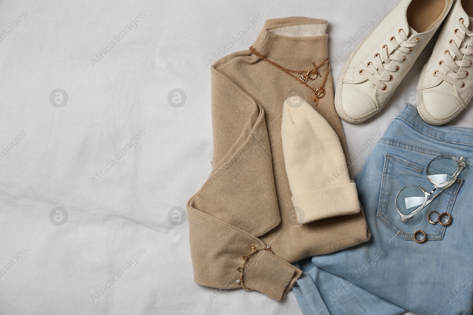 Photo of Stylish look with cashmere sweater, flat lay. Women's clothes and accessories on fabric