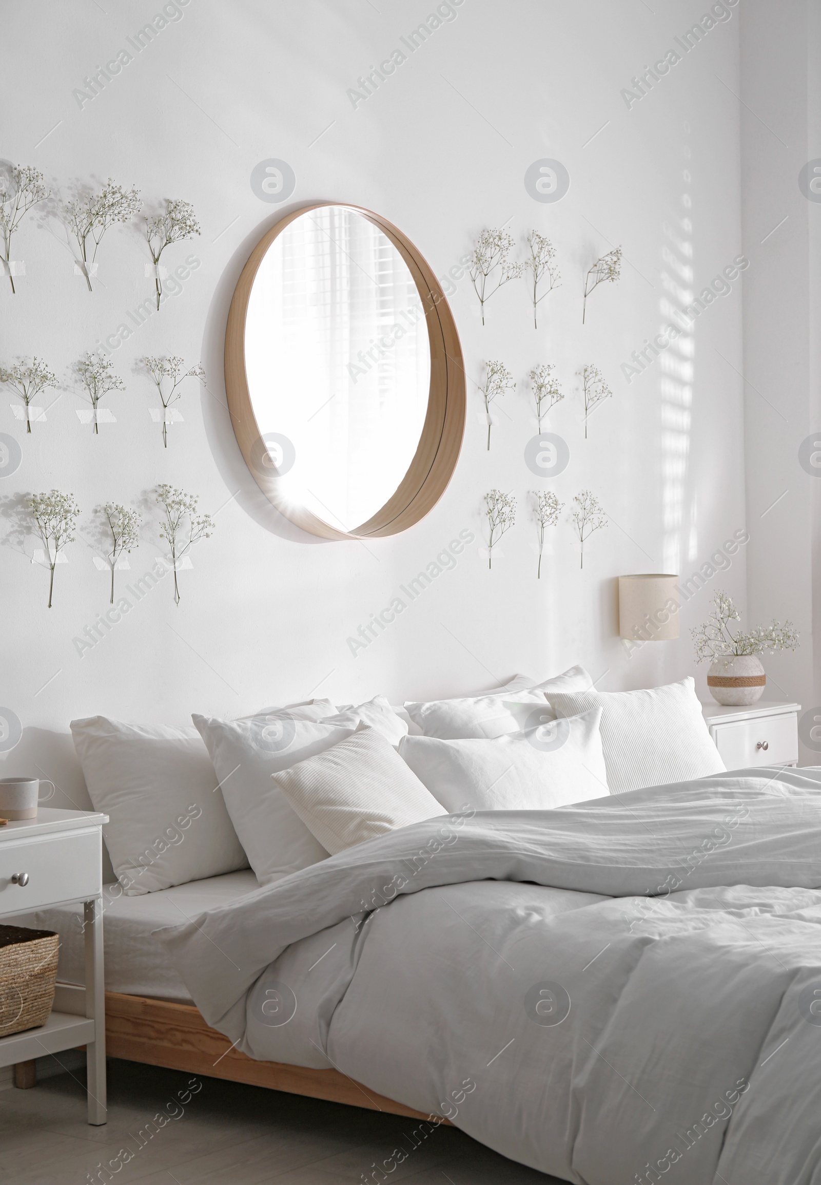 Photo of Modern bedroom interior with stylish round mirror