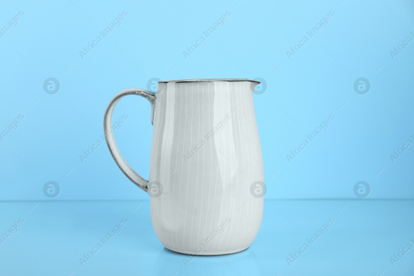 Photo of One white jug on light blue background