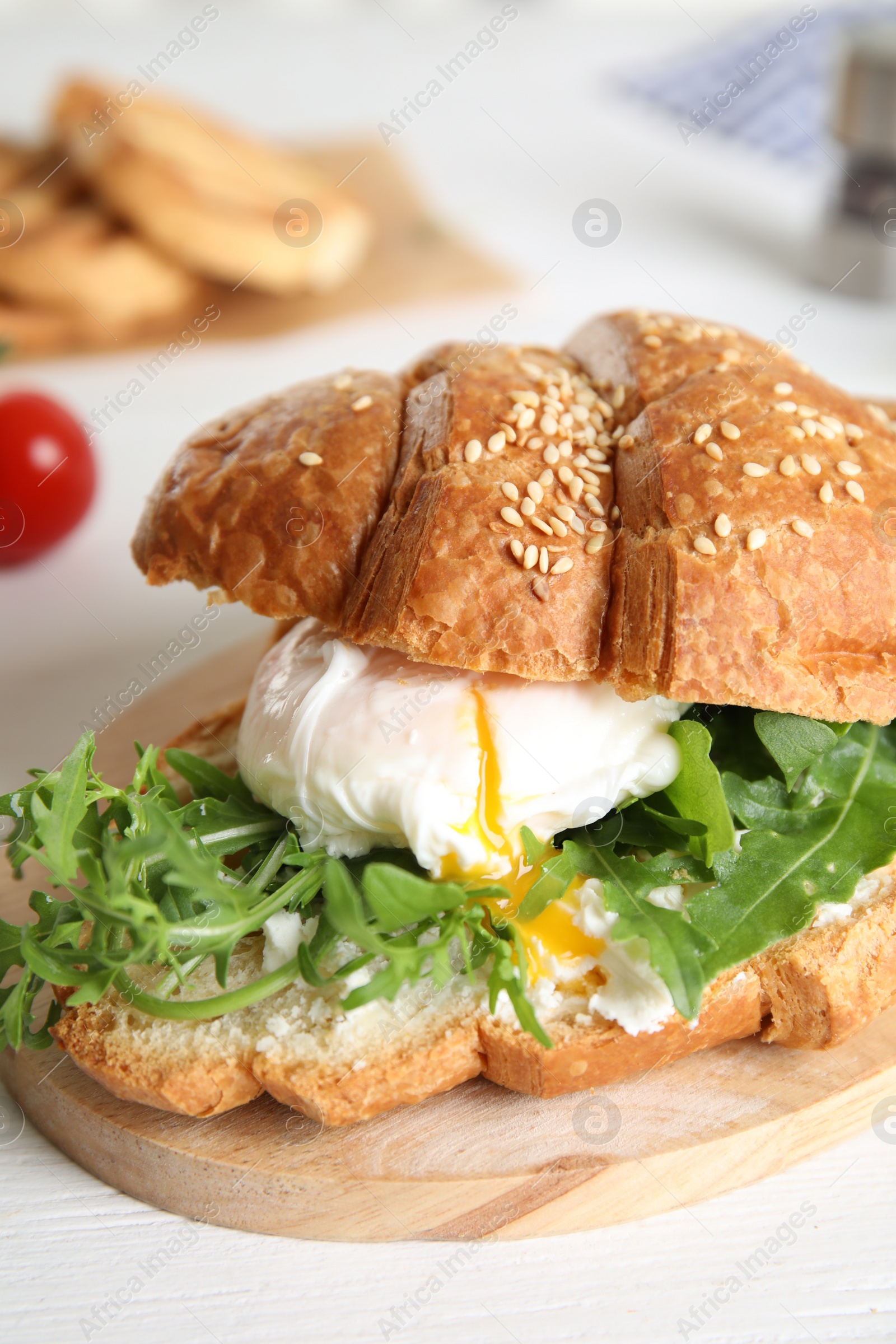 Photo of Delicious croissant with arugula and egg on white wooden table, closeup