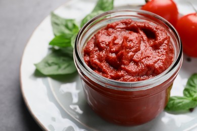 Jar of tasty tomato paste on table, closeup