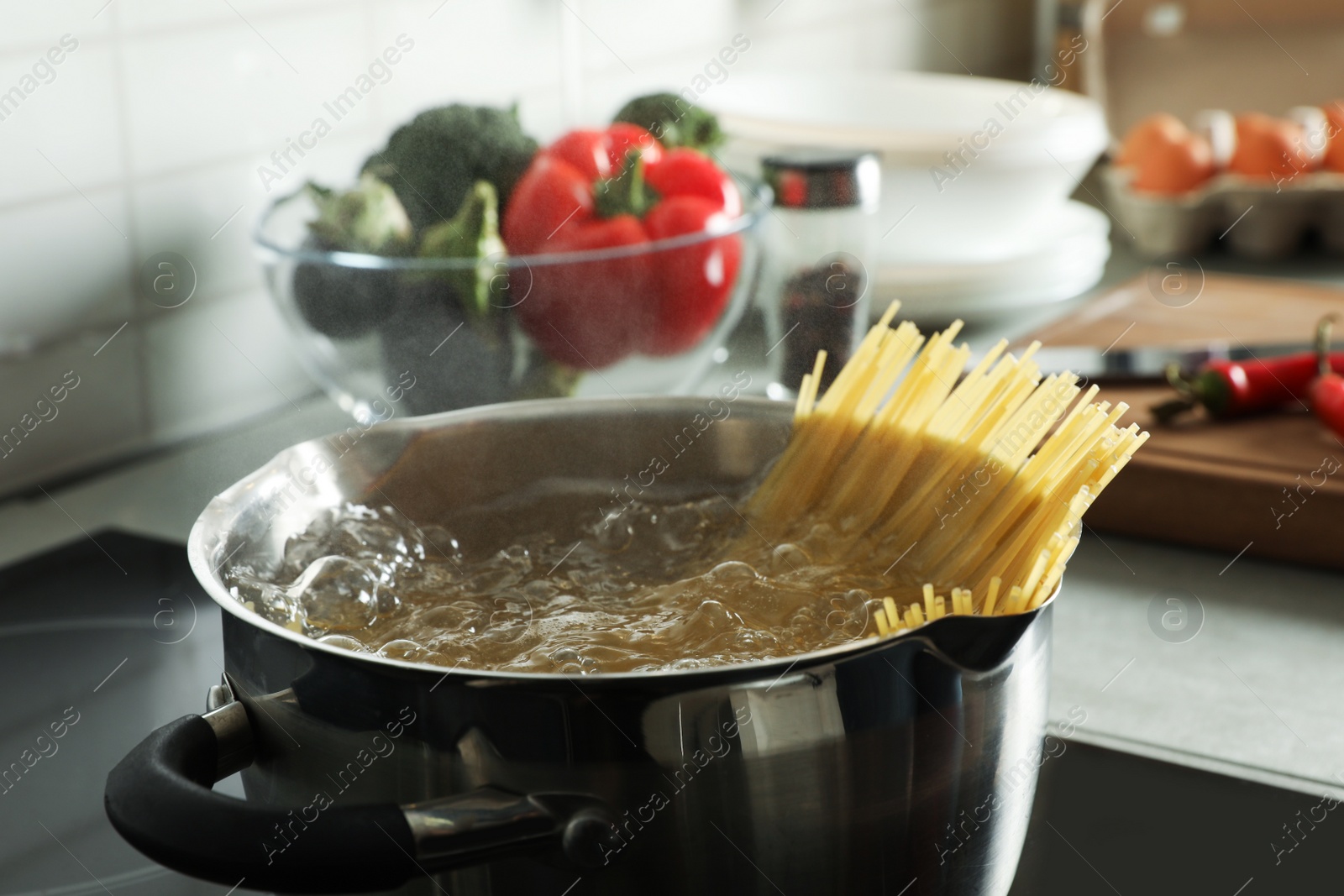 Photo of Cooking spaghetti in pot on electric stove