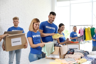 Team of volunteers collecting donations in boxes indoors