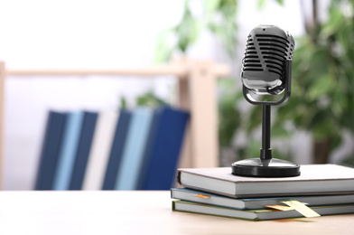 Photo of Retro microphone and notebooks on table indoors, space for text. Job interview