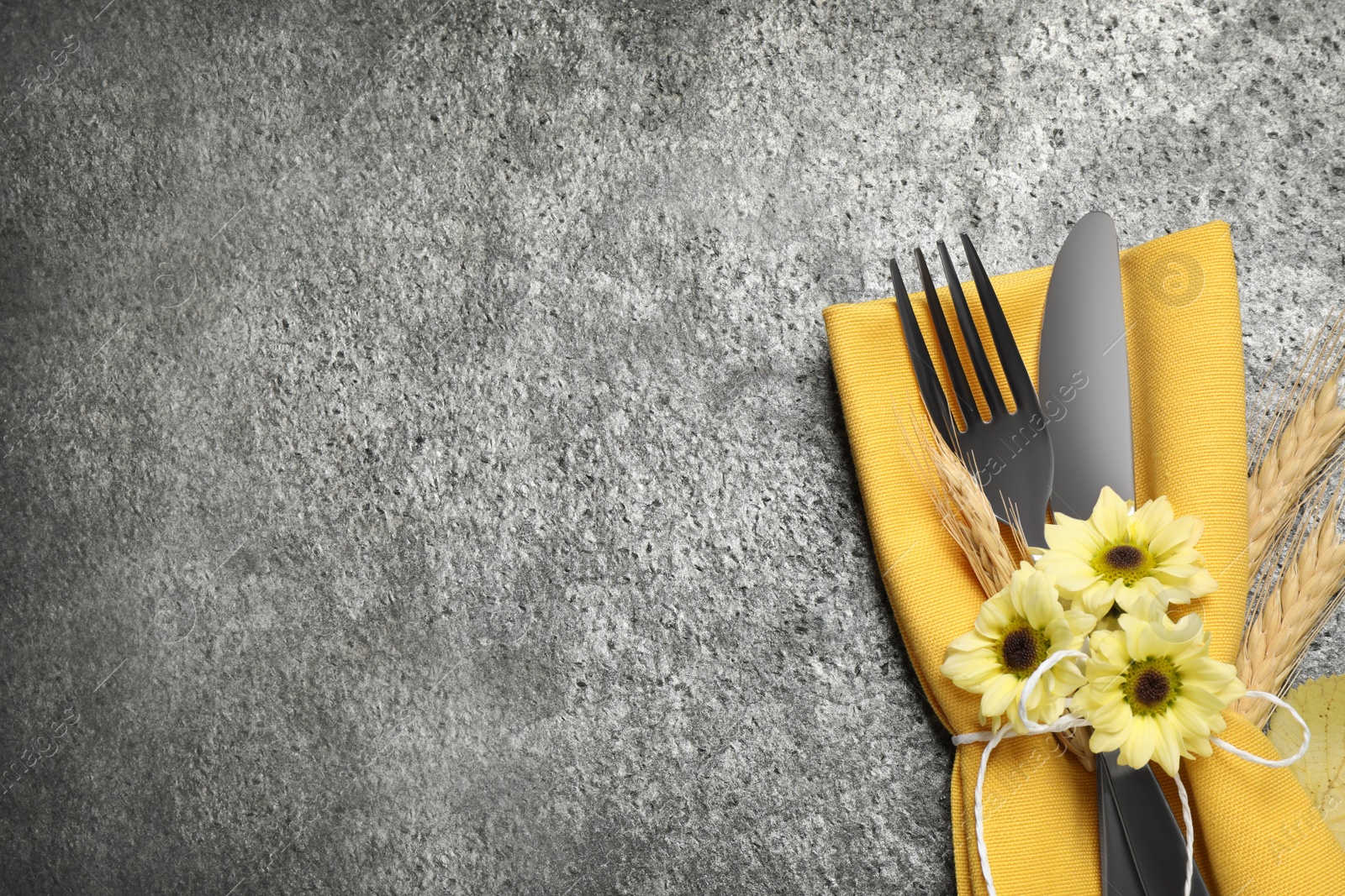 Photo of Cutlery, spikelets and flowers on grey table, flat lay with space for text. Thanksgiving Day celebration