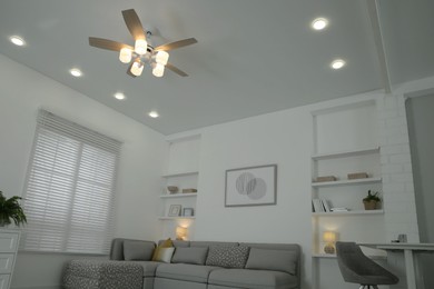 Ceiling fan, furniture and accessories in stylish living room, low angle view