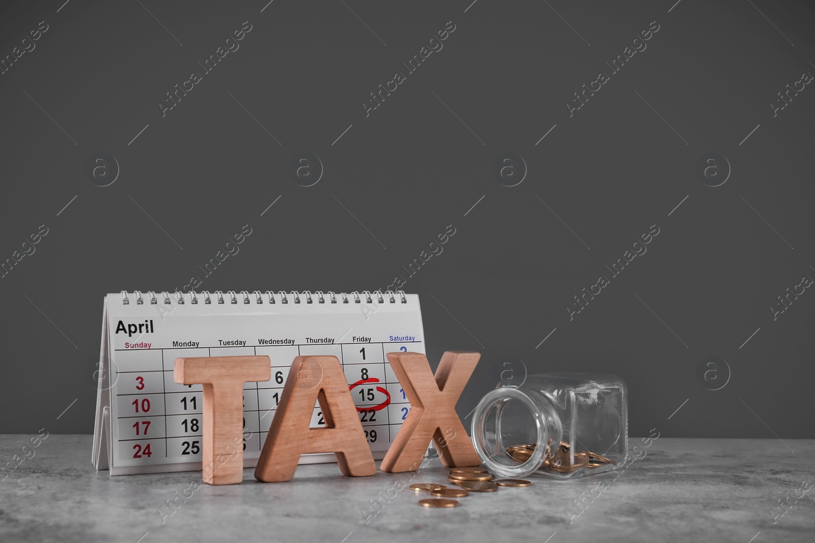 Photo of Word TAX, calendar and jar with money on table