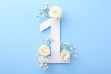 Photo of Paper number 1 and beautiful flowers on light blue background, top view