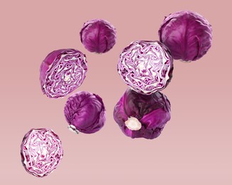 Image of Fresh whole and cut red cabbages flying on pale pink background