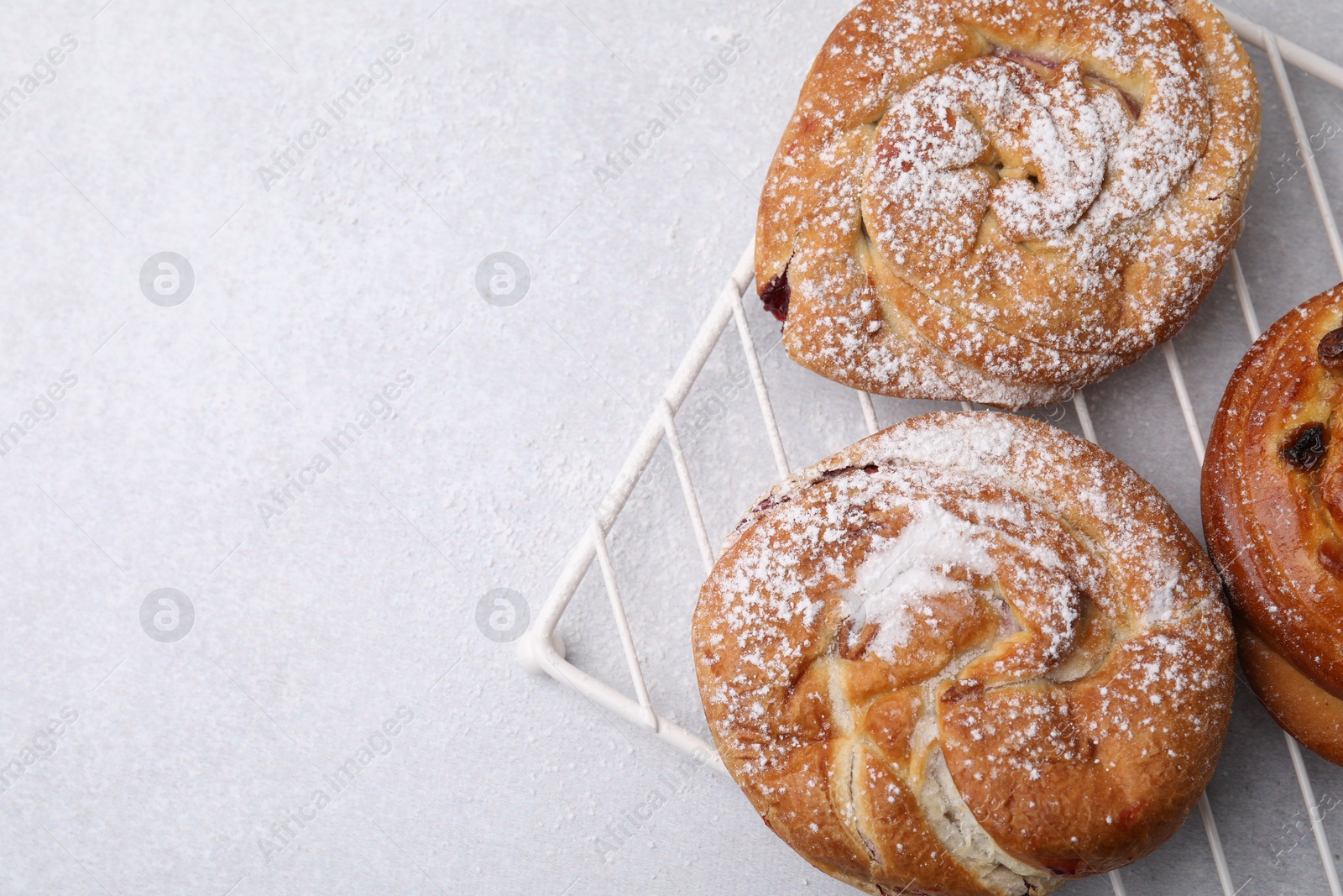 Photo of Different delicious rolls on light table, top view and space for text. Sweet buns