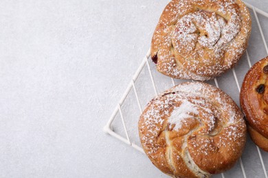 Photo of Different delicious rolls on light table, top view and space for text. Sweet buns