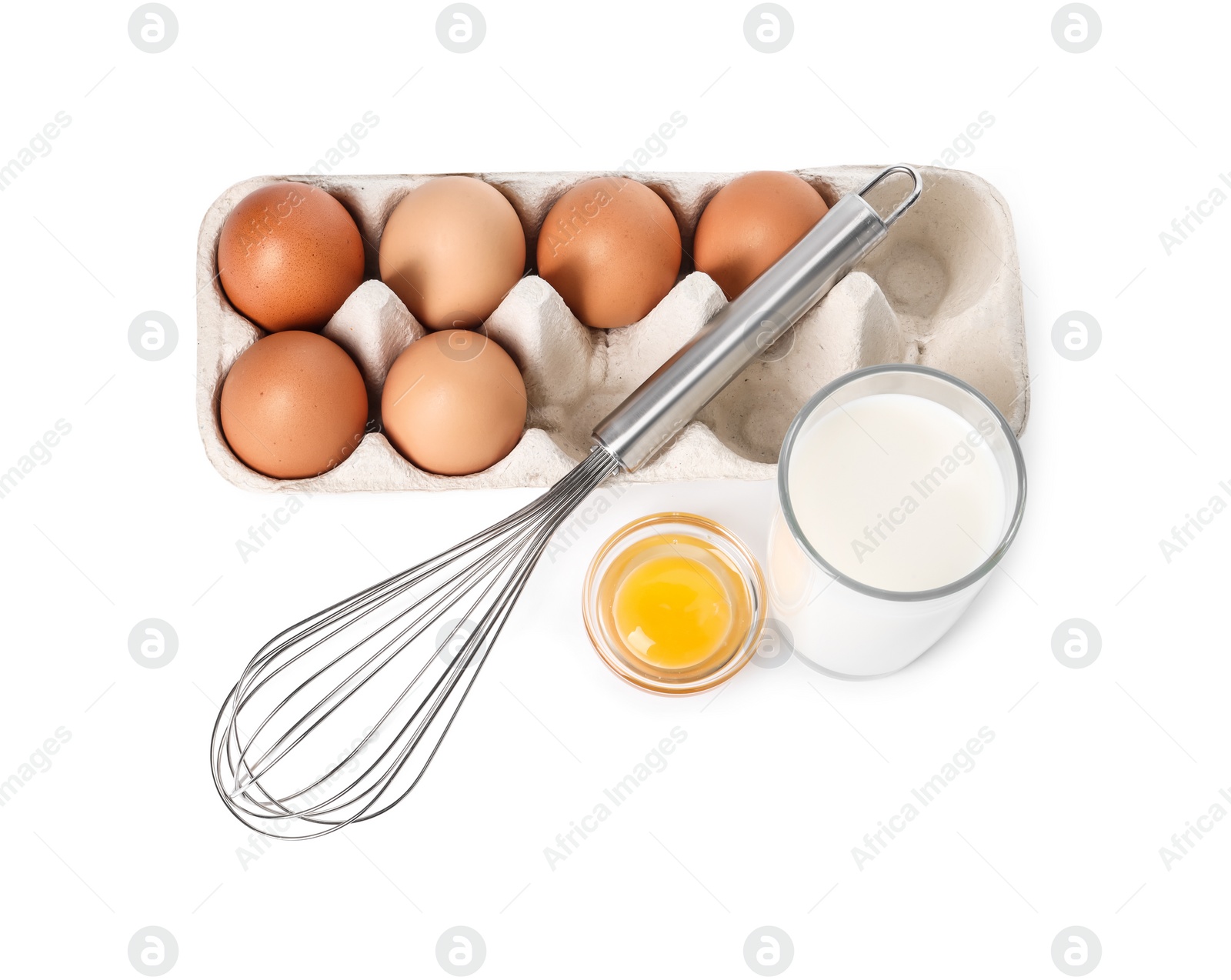 Photo of Metal whisk, raw eggs and glass of milk isolated on white, above view