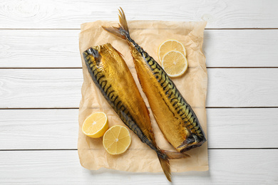 Tasty smoked fish on white wooden table, top view