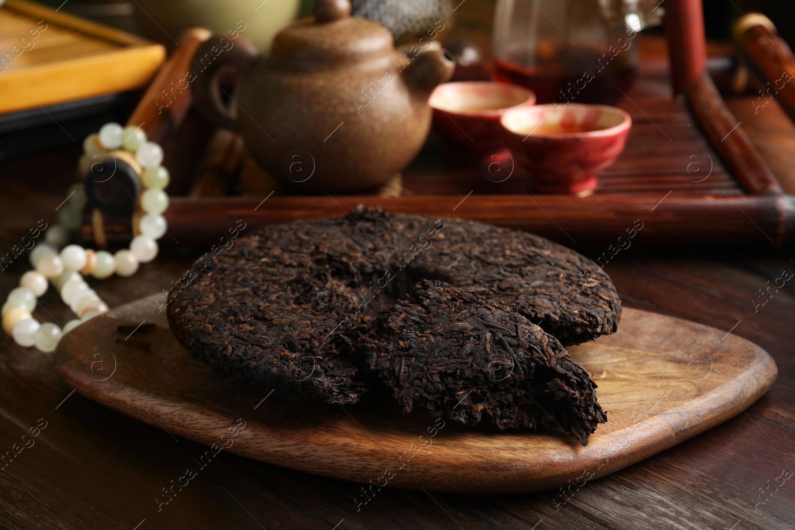 Photo of Broken disc shaped pu-erh tea on wooden table