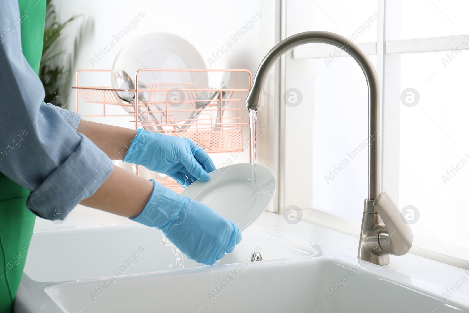 Photo of Woman washing plate in modern kitchen, closeup