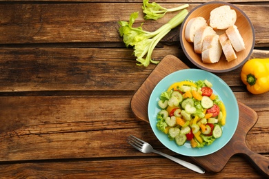 Photo of Delicious fresh celery salad served on wooden table, flat lay. Space for text