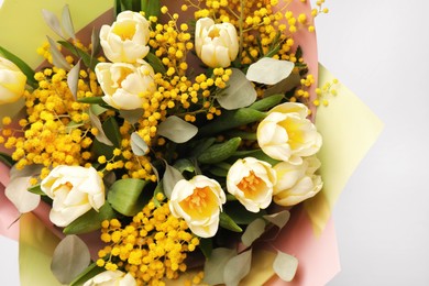 Bouquet of beautiful spring flowers on light grey background, top view