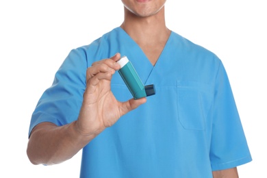 Male doctor holding asthma inhaler on white background, closeup. Medical object