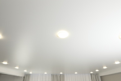 Photo of White ceiling with lamps indoors, below view