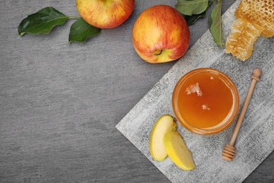 Photo of Flat lay composition with jar of honey, apples and dipper on dark table