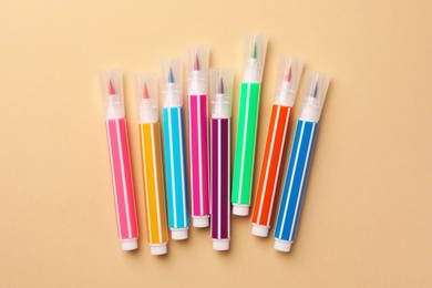 Many bright markers on beige background, flat lay