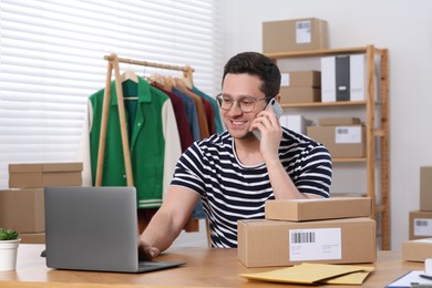 Photo of Seller talking on phone while working in office. Online store