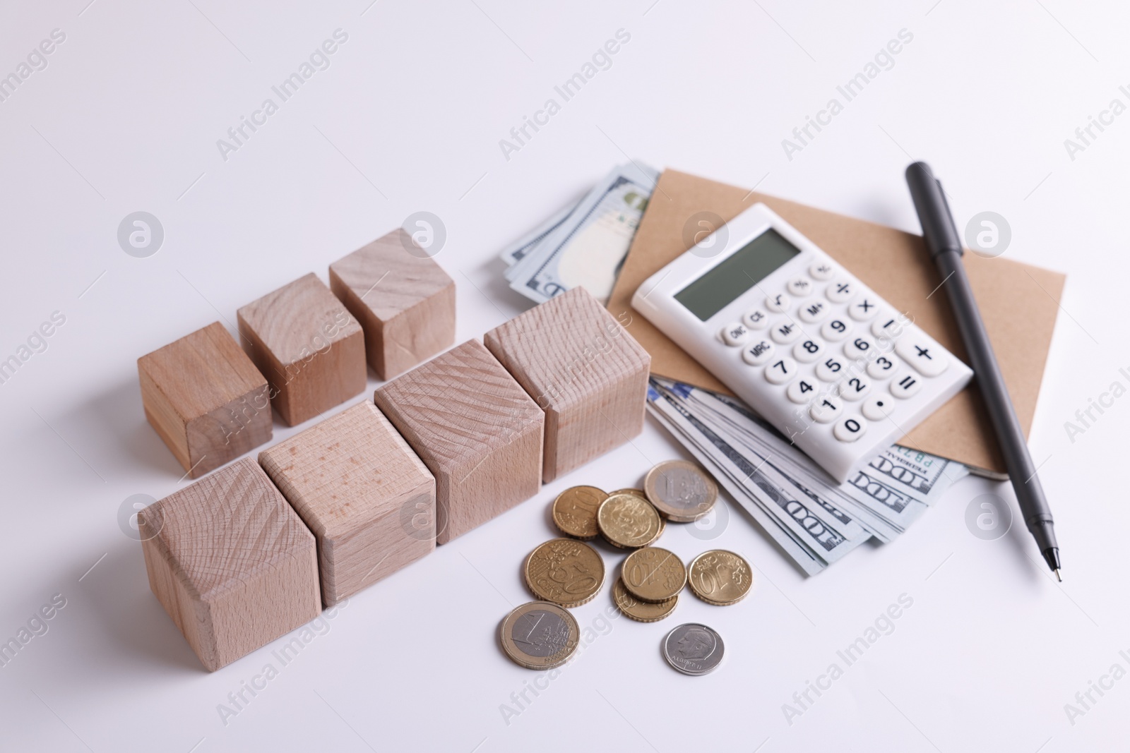 Photo of Taxes. Wooden cubes, calculator, coins and banknotes on white background
