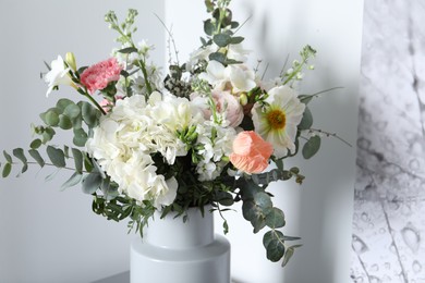 Photo of Bouquet of beautiful flowers near white wall indoors, closeup