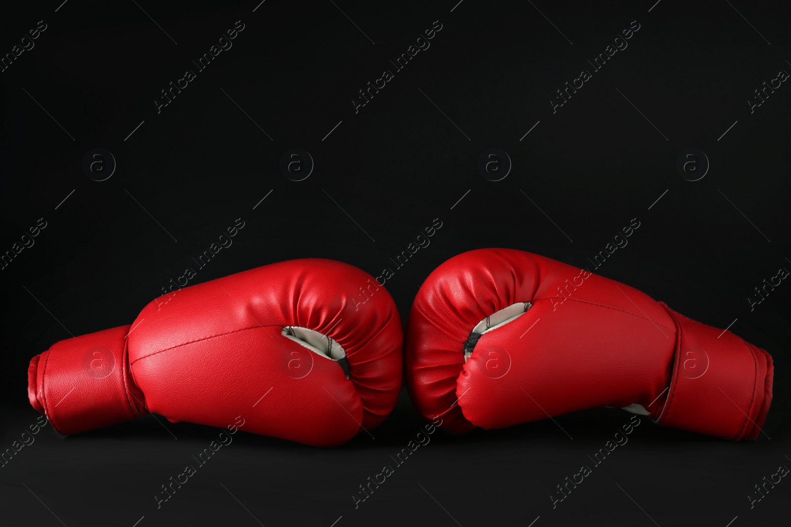 Photo of Red boxing gloves on black marble table. Competition concept