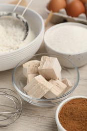 Photo of Flour, leaven and different ingredients on white wooden table. Cooking yeast cake