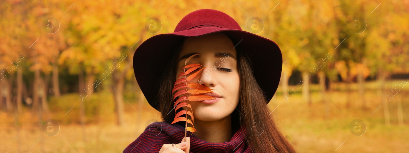 Image of Autumn walk. Young beautiful woman with leaf in park. Banner design