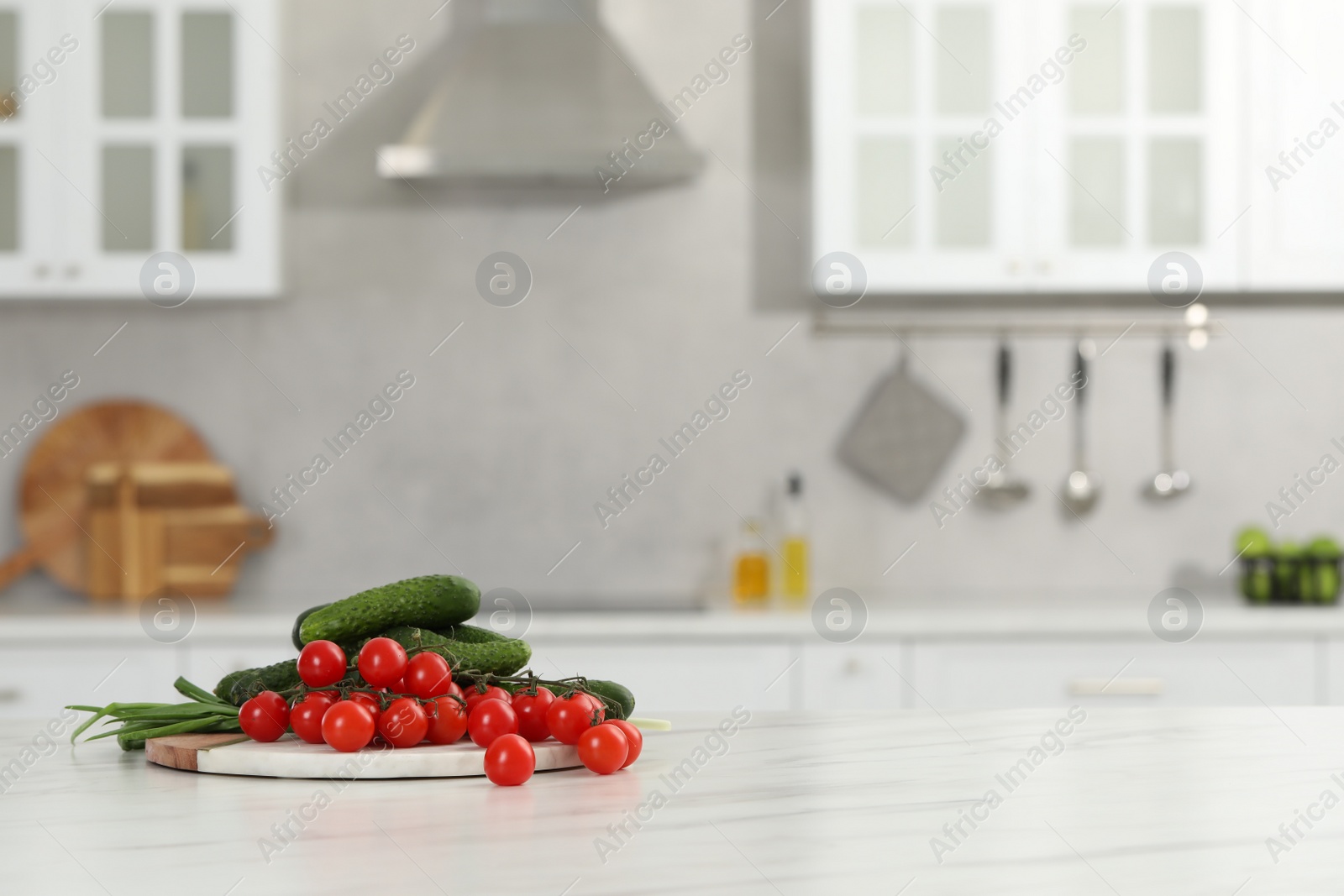 Photo of Fresh clean vegetables on white table in kitchen, space for text