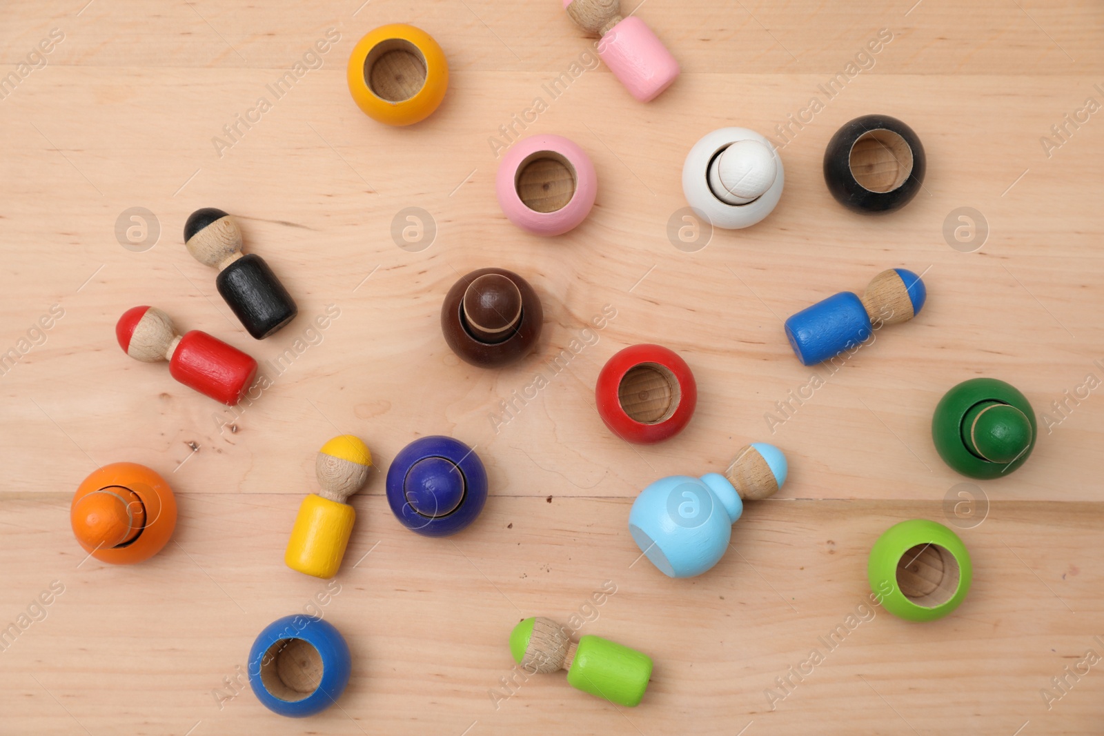 Photo of Wooden colorful dolls shaped building blocks on table, flat lay. Montessori toy