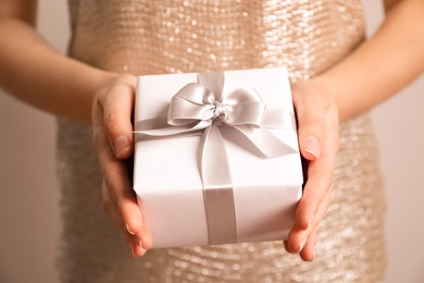 Photo of Woman holding beautiful gift box, closeup