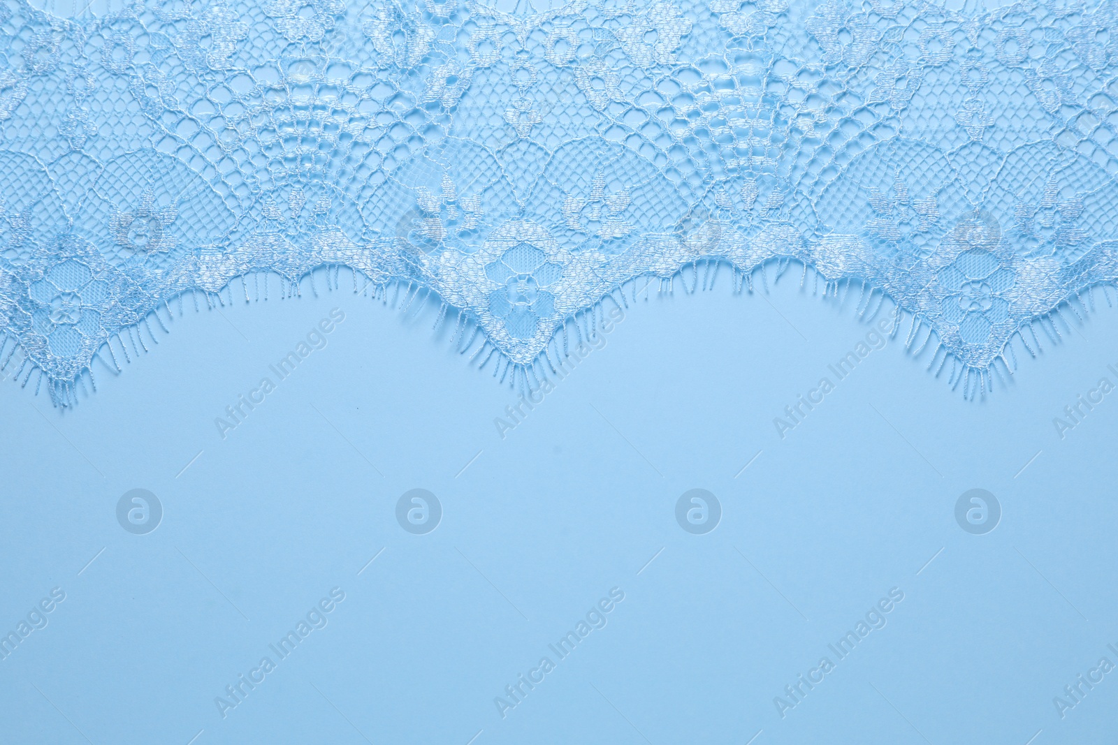 Photo of Beautiful lace on light blue background, top view. Space for text