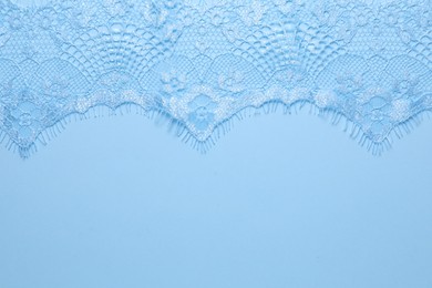 Beautiful lace on light blue background, top view. Space for text