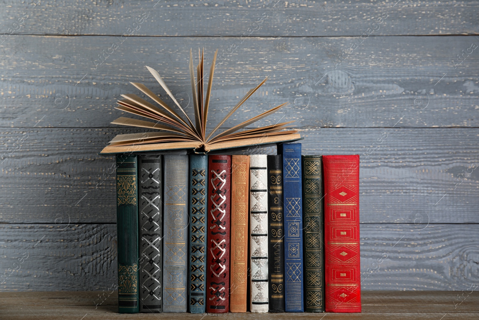 Photo of Stack of hardcover books on grey wooden background