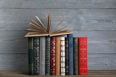 Stack of hardcover books on grey wooden background