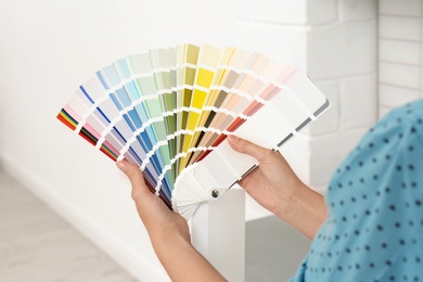 Photo of Female interior designer with color palette samples indoors, closeup