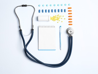 Flat lay composition with medical equipment and pills on light background