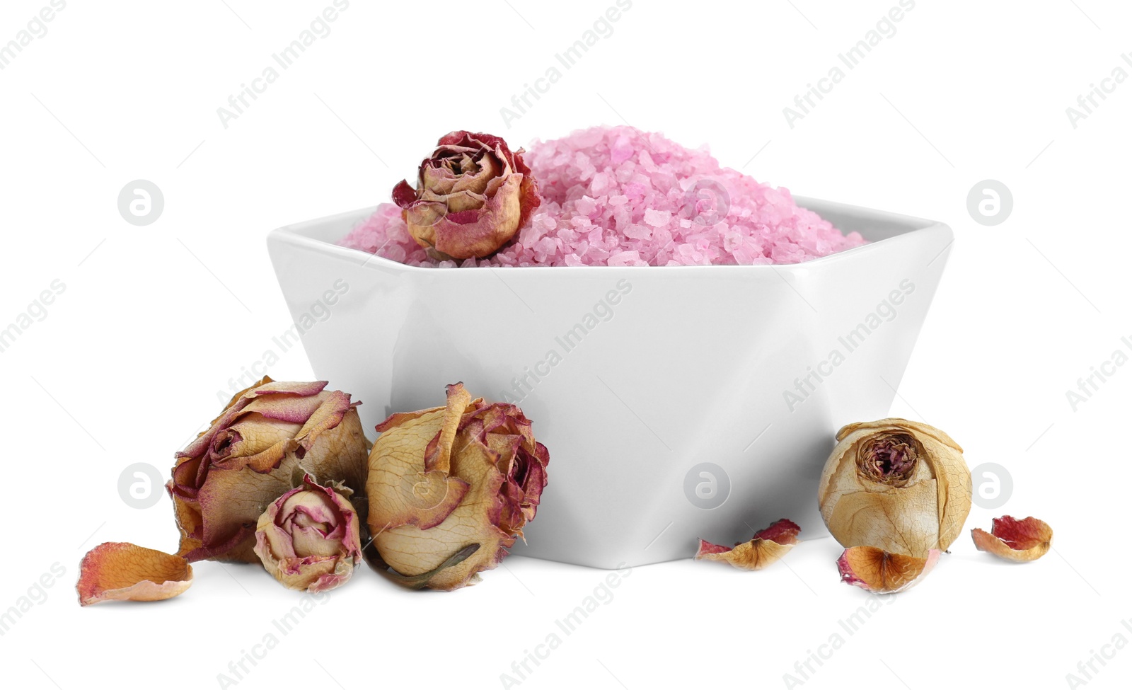Photo of Bowl of pink sea salt and dry rose flowers isolated on white