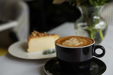 Photo of Cup of fresh coffee and dessert on table indoors