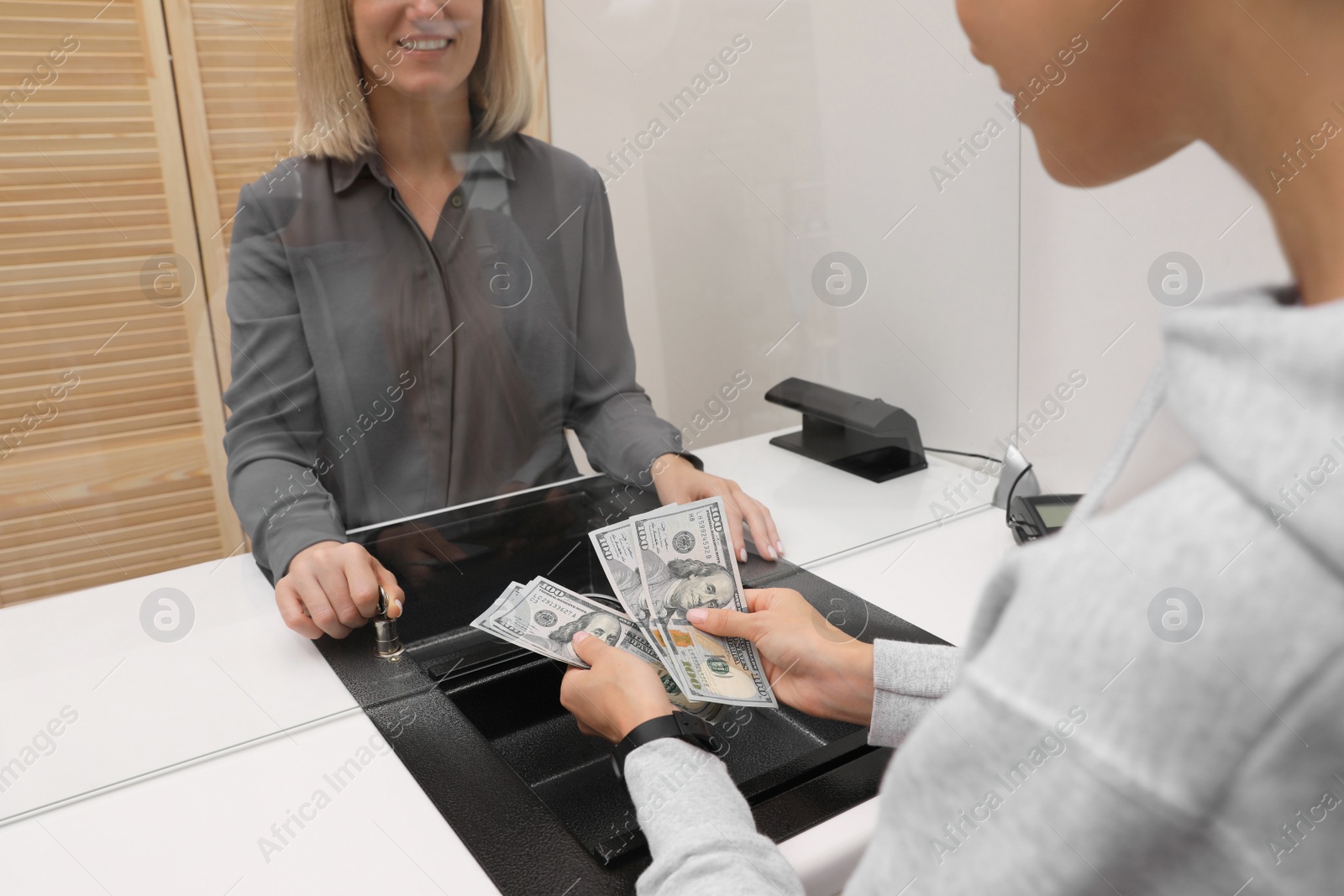 Photo of Woman with money at cash department window, closeup. Currency exchange