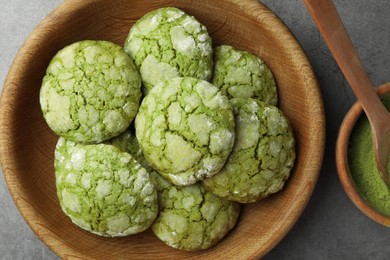 Photo of Bowl with tasty matcha cookies and powder on grey textured table, flat lay