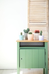 Beautiful different cacti in pots on table