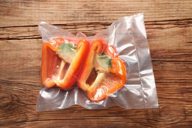 Photo of Vacuum packbell pepper on wooden table, top view