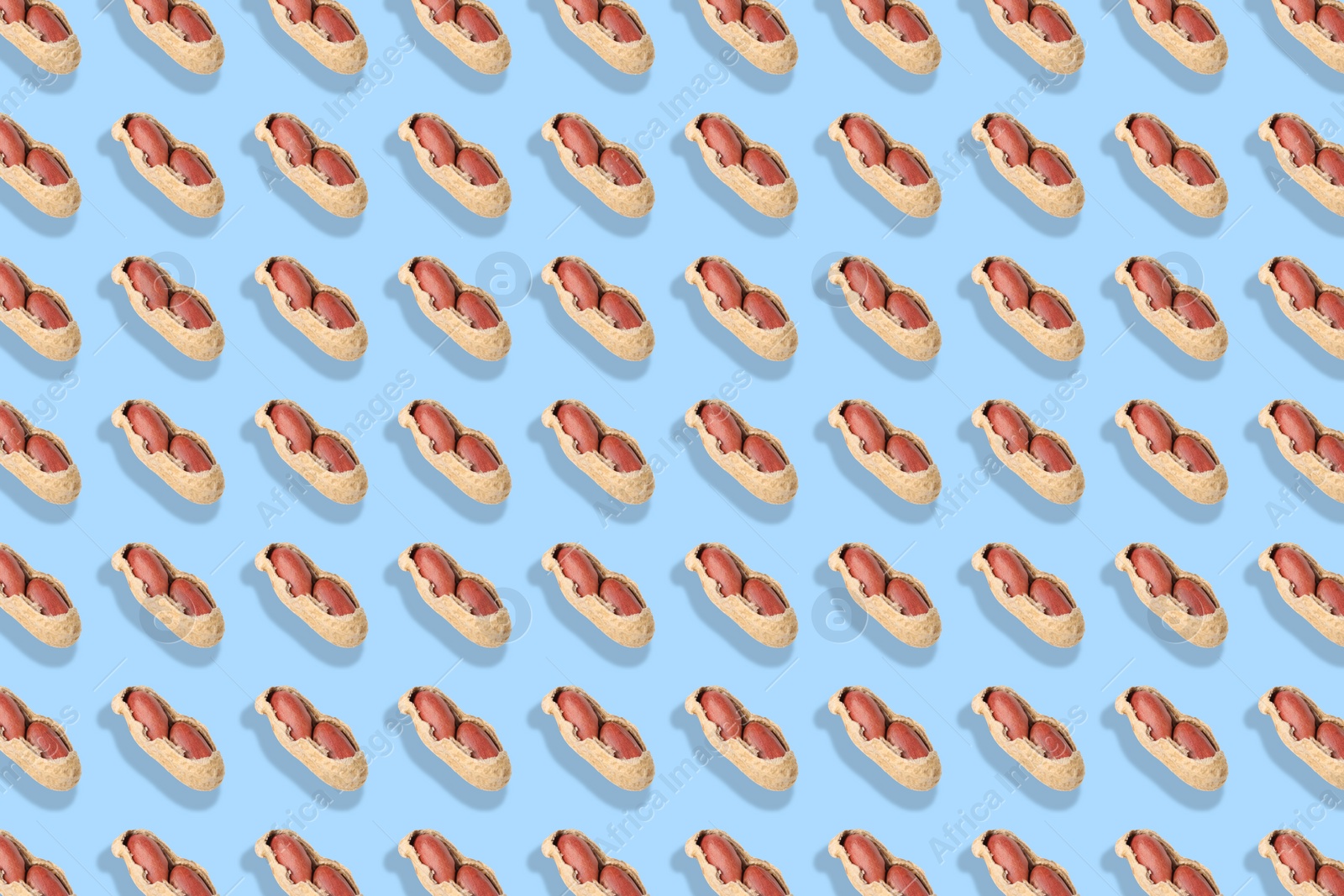 Image of Pattern of unpeeled peanuts on light blue background