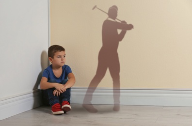 Image of Little boy dreaming to be golf player. Silhouette of man behind kid's back