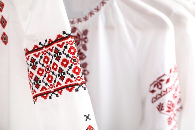 Photo of Beautiful shirts with different embroidery designs, closeup. Ukrainian national clothes
