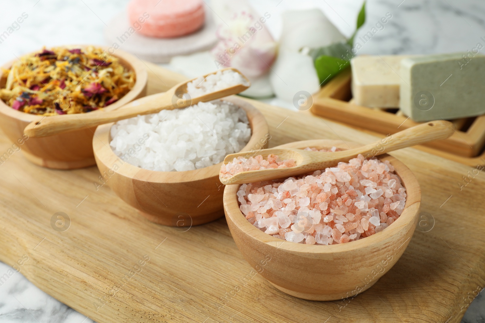 Photo of Spa composition with sea salt and dry flowers in bowls on table